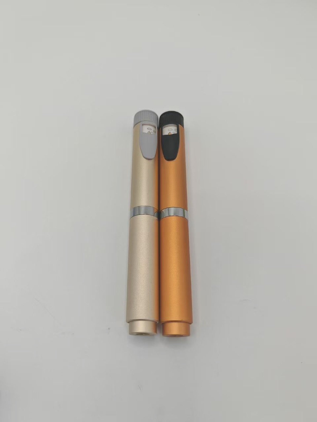 Warm metallic pen injector samples with visible dose scales