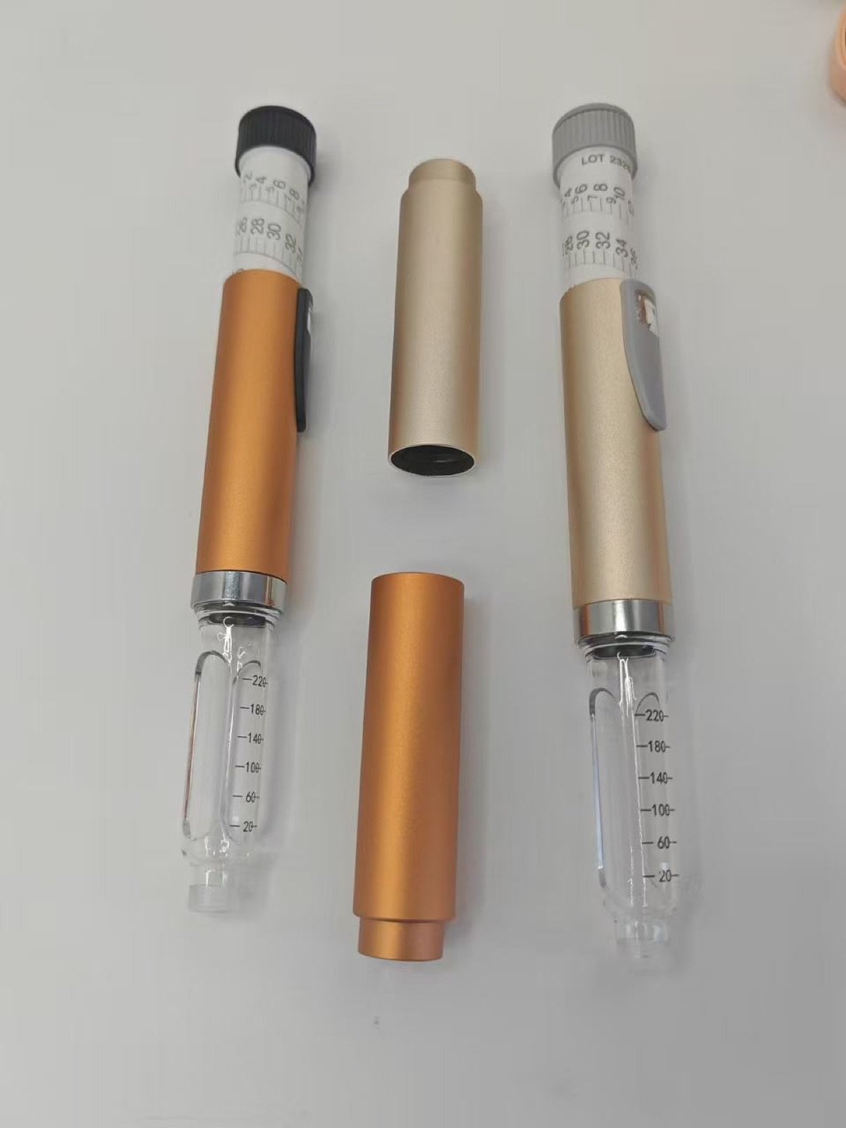 Gold and orange metal pen injector samples
