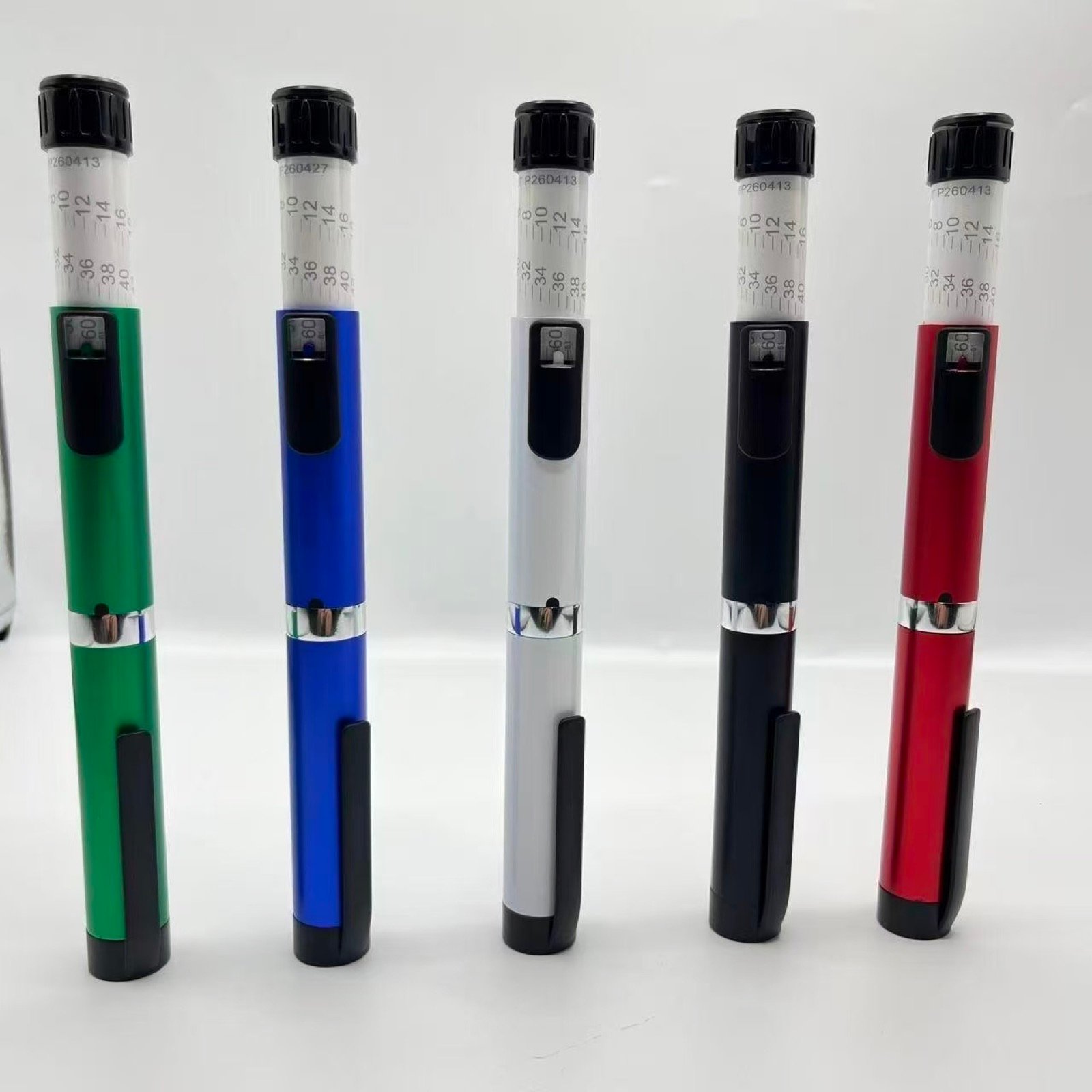 Five metal pen injector samples displayed upright